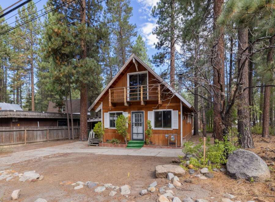 Charming A-frame cabin nestled amongst tall pine trees, offering a serene mountain retreat.