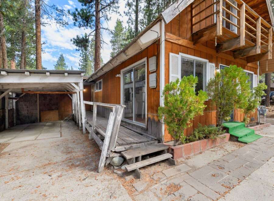 Discover this charming cabin nestled among tall pine trees, offering a rustic retreat.