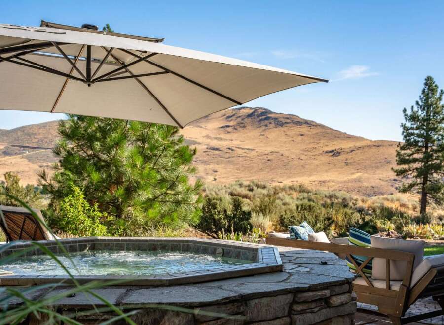Relax and unwind in this luxurious outdoor oasis featuring a bubbling hot tub perfect for soaking under the sun.