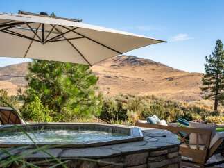 Relax and unwind in this luxurious outdoor oasis featuring a bubbling hot tub perfect for soaking under the sun.