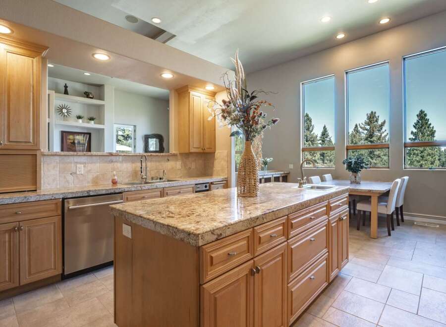 Experience luxury living in this stunning kitchen, featuring a spacious granite island perfect for entertaining and meal prep.