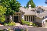 Discover this stunning home featuring a grand double-door entrance and a beautifully landscaped front yard with vibrant flowers and lush greenery.