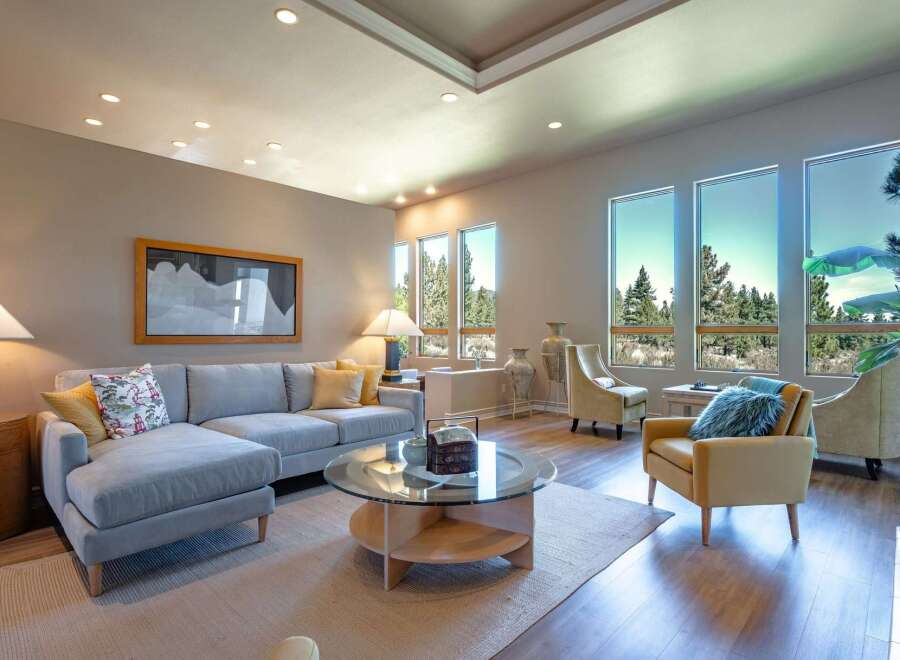 Experience luxury living in this stunning living room, featuring a spacious sectional sofa and elegant armchairs perfect for relaxation.