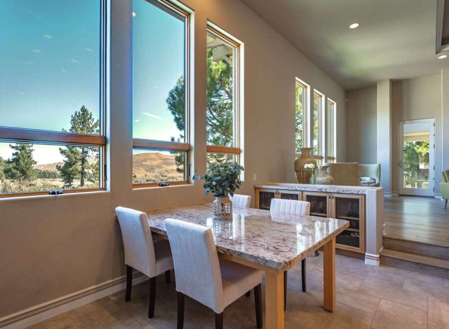 Experience breathtaking views from this dining area, featuring expansive windows that showcase the natural landscape.