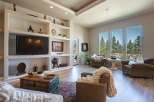 Experience breathtaking panoramic views from this stunning living room, featuring expansive windows that showcase a lush forest landscape.