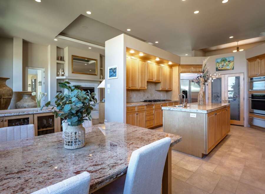 Experience luxury living in this stunning kitchen and dining area, featuring a spacious granite-topped island perfect for entertaining.