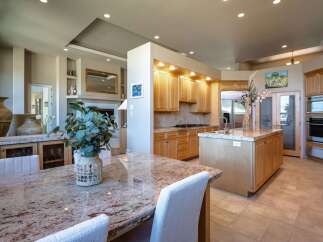Experience luxury living in this stunning kitchen and dining area, featuring a spacious granite-topped island perfect for entertaining.