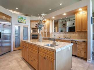 Experience luxury in this spacious kitchen featuring a large granite island with a built-in sink, perfect for meal prep and entertaining.