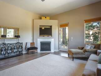 This inviting living room features a modern fireplace with a mounted television, perfect for cozy evenings.