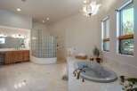 Indulge in luxury in this spacious master bathroom, featuring a large soaking tub and a separate glass-block shower enclosure.