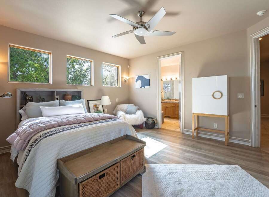 This inviting bedroom features a cozy bed with plush bedding, complemented by a stylish headboard with built-in shelving.