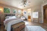 This inviting bedroom features a cozy bed with plush bedding, complemented by a stylish headboard with built-in shelving.