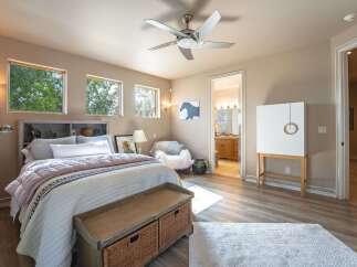 This inviting bedroom features a cozy bed with plush bedding, complemented by a stylish headboard with built-in shelving.