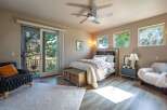 Experience serene living in this charming bedroom featuring a comfortable bed, a rustic wooden storage bench, and a cozy armchair.