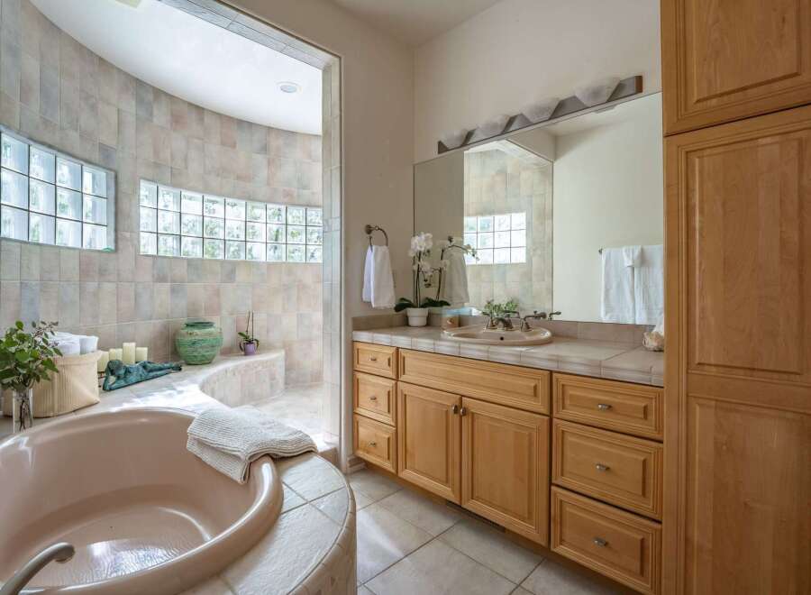 Indulge in relaxation in this luxurious bathroom featuring a spacious, curved soaking tub and a separate shower area.