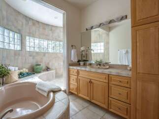 Indulge in relaxation in this luxurious bathroom featuring a spacious, curved soaking tub and a separate shower area.