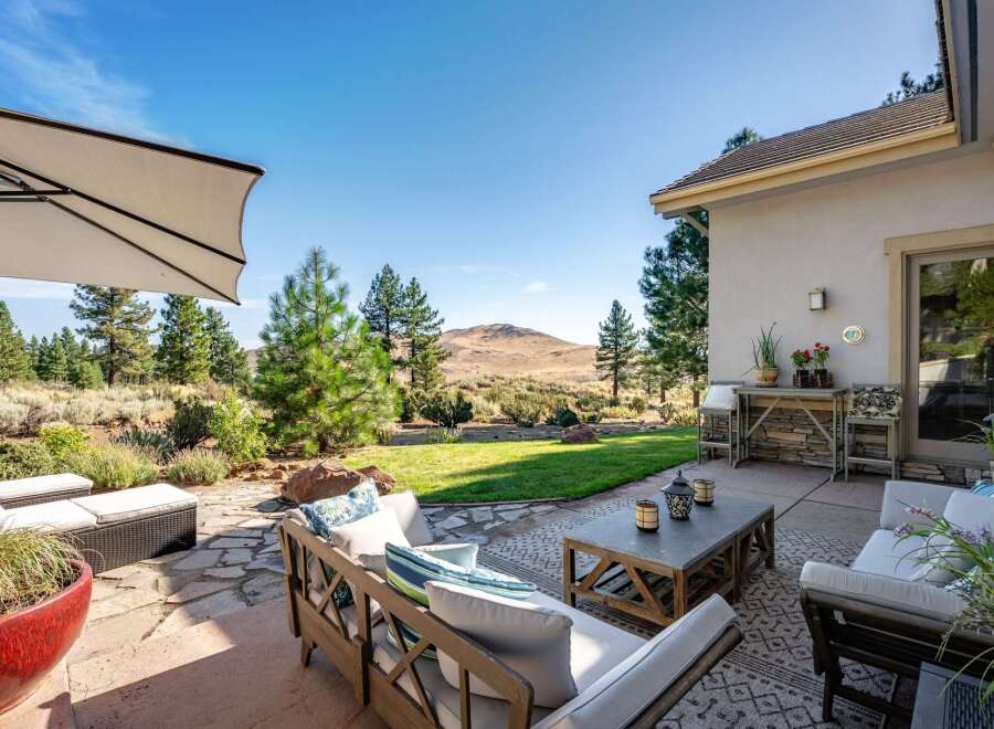 Enjoy outdoor living with this spacious patio featuring comfortable seating and a coffee table, perfect for entertaining.