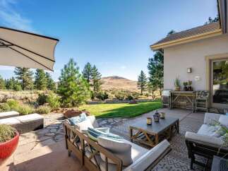 Enjoy outdoor living with this spacious patio featuring comfortable seating and a coffee table, perfect for entertaining.