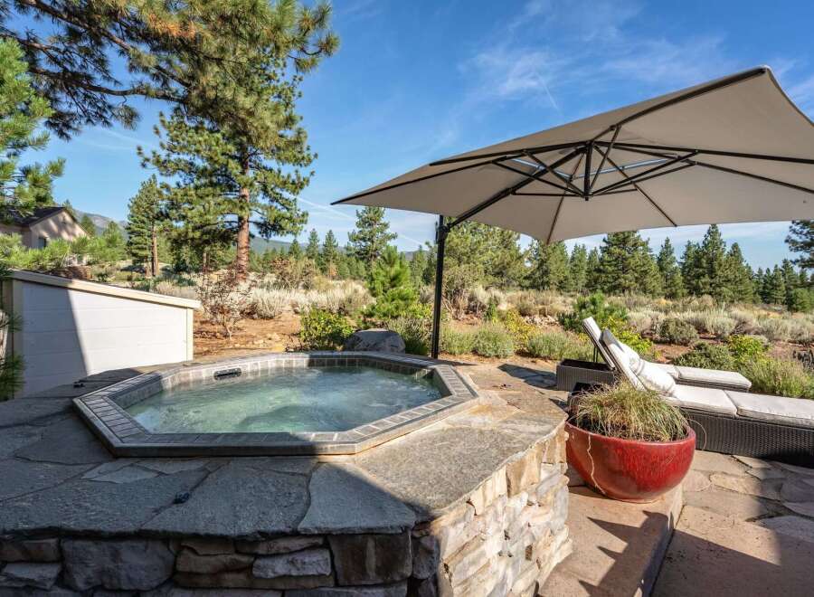 Relax and unwind in this stunning outdoor oasis, featuring a luxurious hot tub surrounded by natural stone and a spacious patio perfect for entertaining.