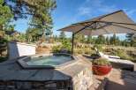 Relax and unwind in this stunning outdoor oasis, featuring a luxurious hot tub surrounded by natural stone and a spacious patio perfect for entertaining.
