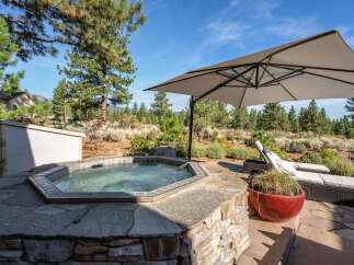 Relax and unwind in this stunning outdoor oasis, featuring a luxurious hot tub surrounded by natural stone and a spacious patio perfect for entertaining.