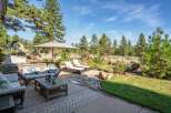 Enjoy outdoor living at its finest with this stunning patio featuring comfortable seating, chaise lounges, and a large umbrella for shade.