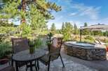 Enjoy outdoor living at its finest with this stunning patio featuring a luxurious stone-encased hot tub, perfect for relaxation.