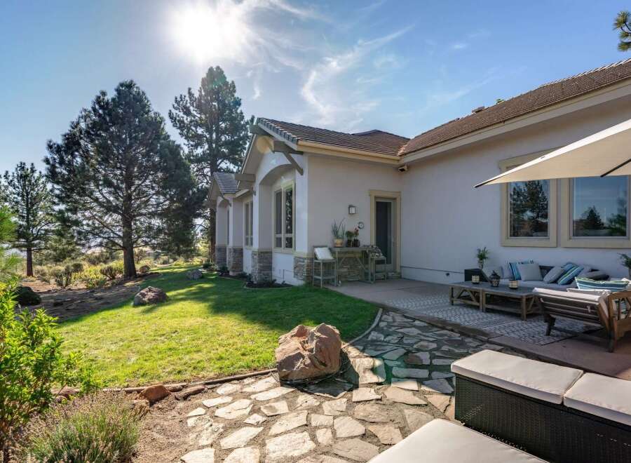 Enjoy outdoor living with this spacious patio featuring comfortable seating and a large umbrella for shade.