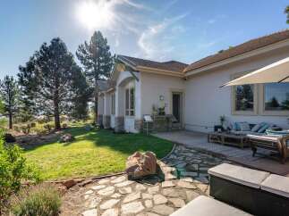 Enjoy outdoor living with this spacious patio featuring comfortable seating and a large umbrella for shade.