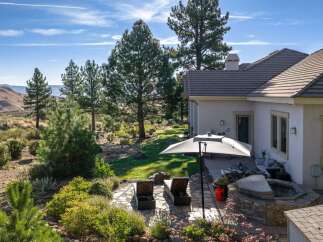 Experience luxurious outdoor living with this stunning backyard oasis, featuring a relaxing hot tub and comfortable lounge chairs perfect for soaking up the sun.