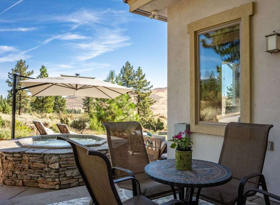 Enjoy outdoor living at its finest with this stunning patio featuring a luxurious stone-encased hot tub perfect for relaxation.