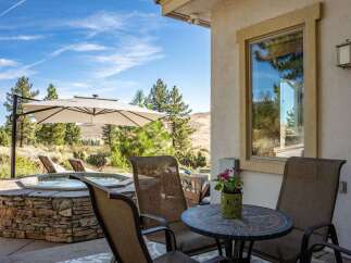 Enjoy outdoor living at its finest with this stunning patio featuring a luxurious stone-encased hot tub perfect for relaxation.