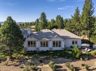 This stunning single-story home offers a luxurious retreat surrounded by mature pine trees and breathtaking mountain views.