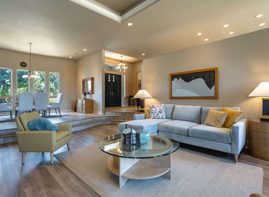 Experience elegant living in this spacious home, featuring a sophisticated living area with a plush sectional sofa and a stylish coffee table.