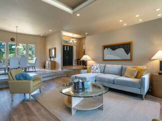 Experience elegant living in this spacious home, featuring a sophisticated living area with a plush sectional sofa and a stylish coffee table.