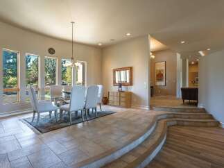 Experience elegant dining in this spacious room featuring a glass-top dining table with upholstered chairs, perfect for hosting gatherings.