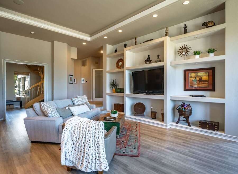 Step into this inviting living room featuring a spacious sectional sofa adorned with decorative pillows and a cozy knit throw.