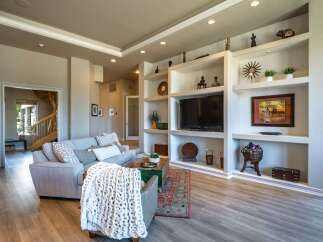 Step into this inviting living room featuring a spacious sectional sofa adorned with decorative pillows and a cozy knit throw.