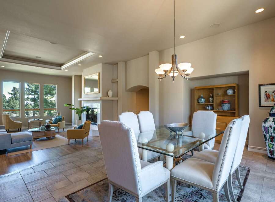 Experience elegant dining in this spacious room, featuring a glass-top dining table with comfortable upholstered chairs, perfect for hosting gatherings.