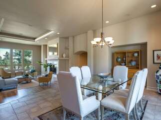 Experience elegant dining in this spacious room, featuring a glass-top dining table with comfortable upholstered chairs, perfect for hosting gatherings.