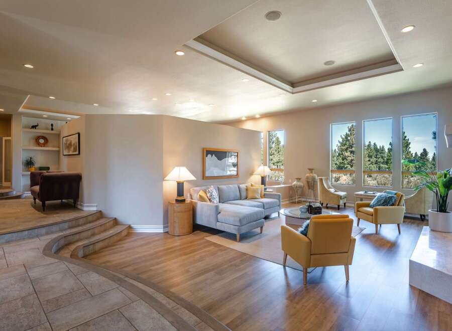 Experience luxurious living in this spacious great room, featuring a large sectional sofa and comfortable accent chairs perfect for entertaining.