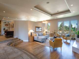 Experience luxurious living in this spacious great room, featuring a large sectional sofa and comfortable accent chairs perfect for entertaining.