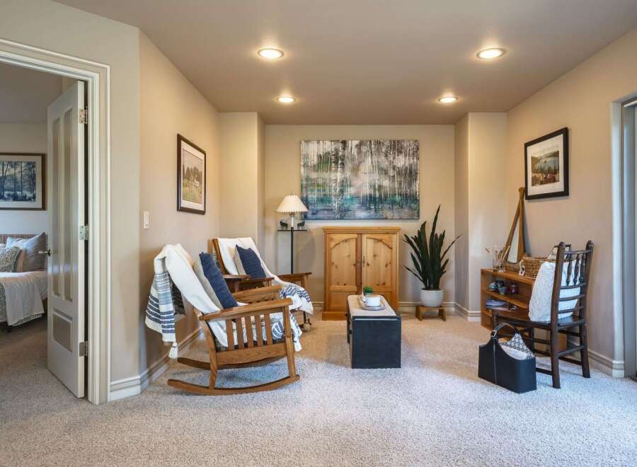 This inviting living space features two comfortable wooden rocking chairs adorned with cozy throws and pillows, perfect for relaxation.