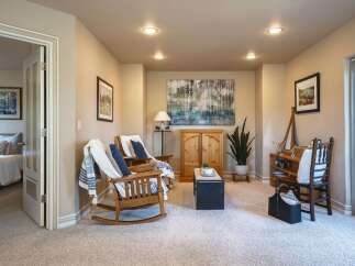 This inviting living space features two comfortable wooden rocking chairs adorned with cozy throws and pillows, perfect for relaxation.