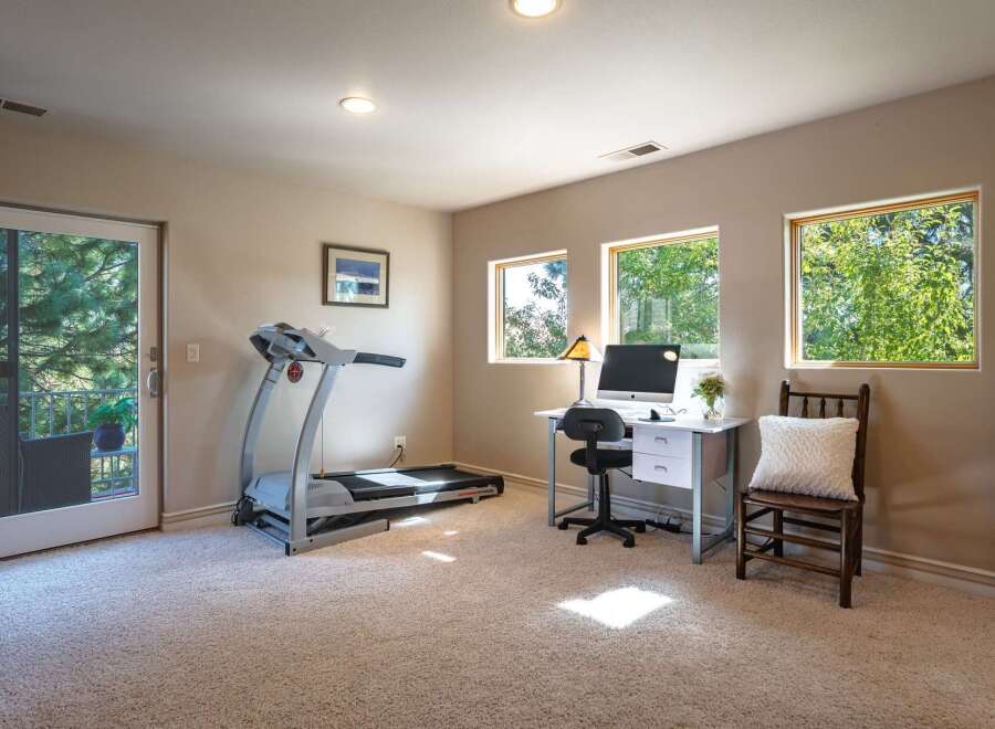 This versatile room offers a perfect blend of fitness and productivity, featuring a treadmill for your workouts and a dedicated desk space with a computer for work.