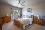 Experience comfort and style in this inviting bedroom, featuring a plush queen-size bed adorned with decorative pillows and a cozy throw blanket.