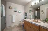 This bright and airy bathroom features a spacious vanity with a light pink sink and ample counter space, perfect for your morning routine.