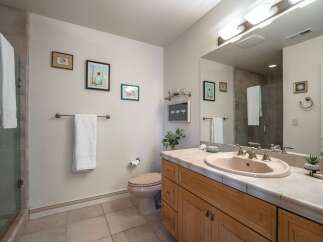 This bright and airy bathroom features a spacious vanity with a light pink sink and ample counter space, perfect for your morning routine.