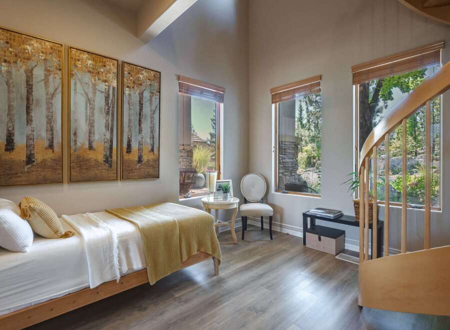 This charming bedroom features a cozy twin bed adorned with a yellow knit blanket and white linens, perfect for relaxation.