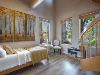 This charming bedroom features a cozy twin bed adorned with a yellow knit blanket and white linens, perfect for relaxation.